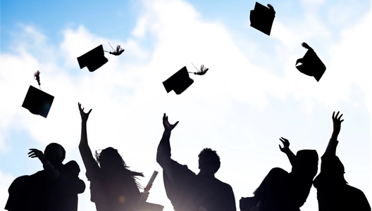 A group of people throwing their caps in the air.