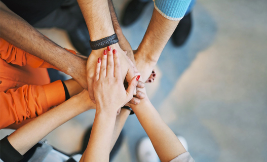 A group of people with their hands together.